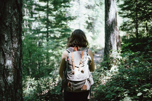woman with a backpack in the wood - packing list